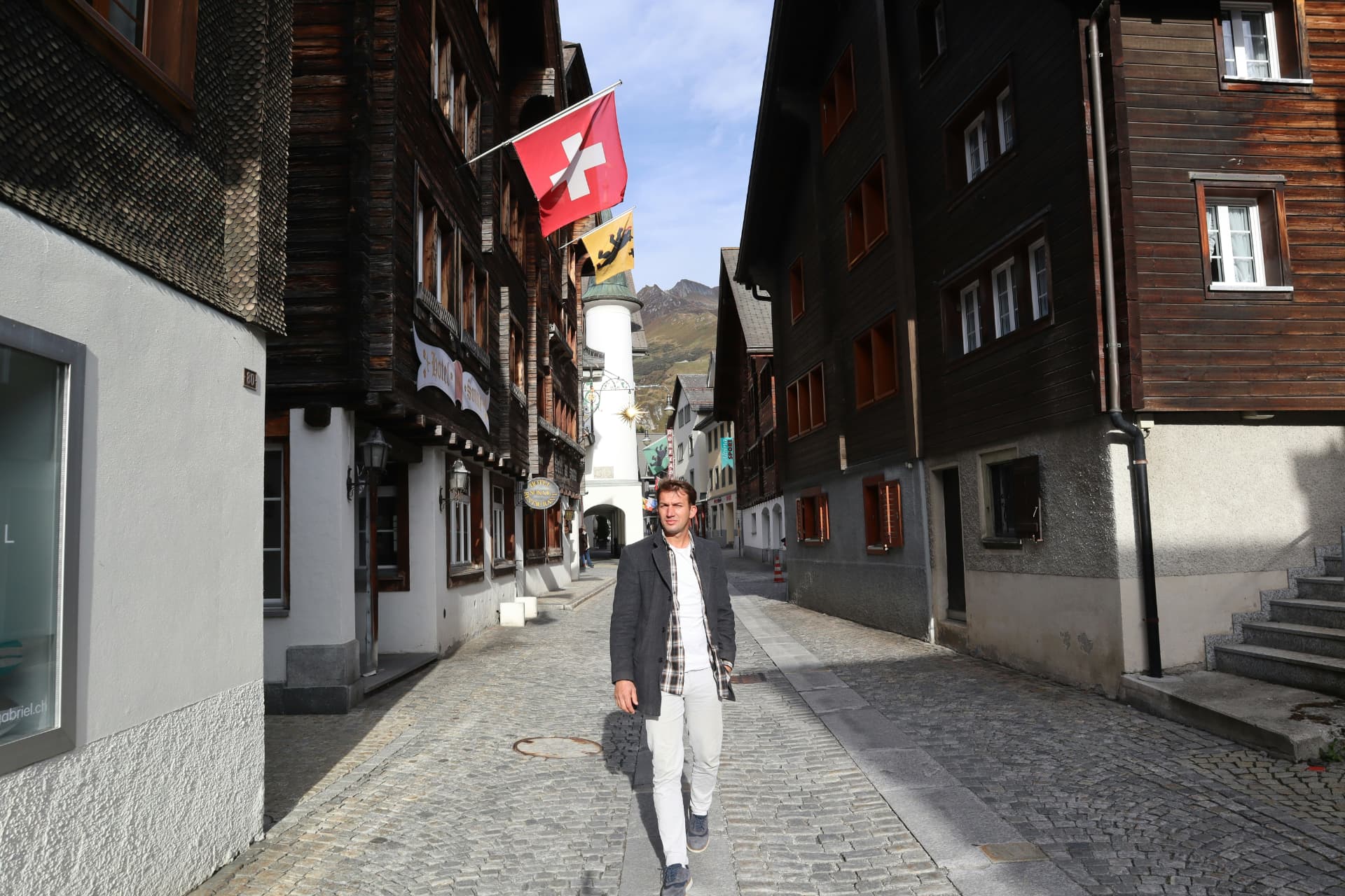 Marco, der Schweizer Investor hinter Schweizer Investor, geht durch eine Alpendorfstrasse